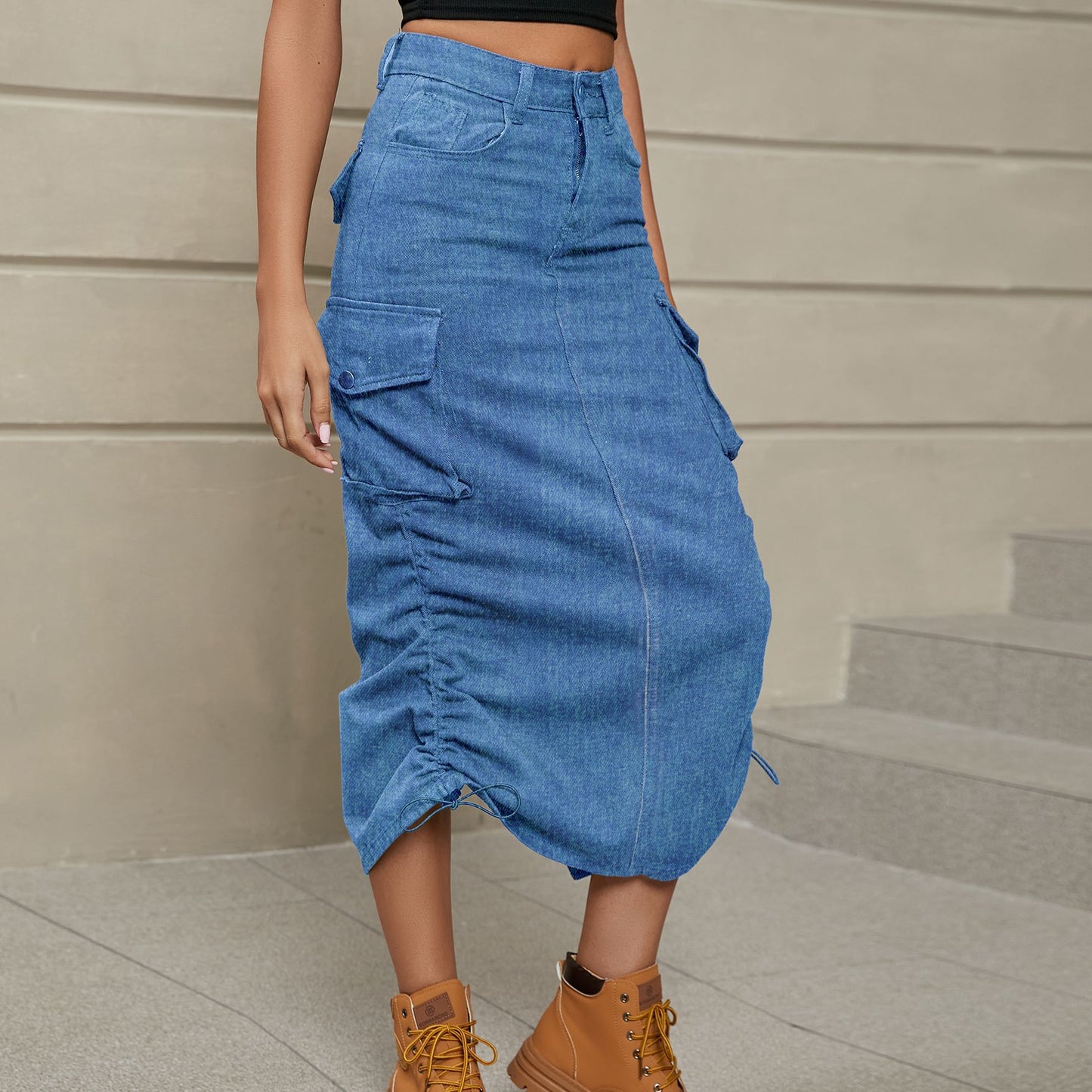 Front left facing view of model wearing drawstring ruched skirt in the color denim. Drawstings on both sides of skirt. 