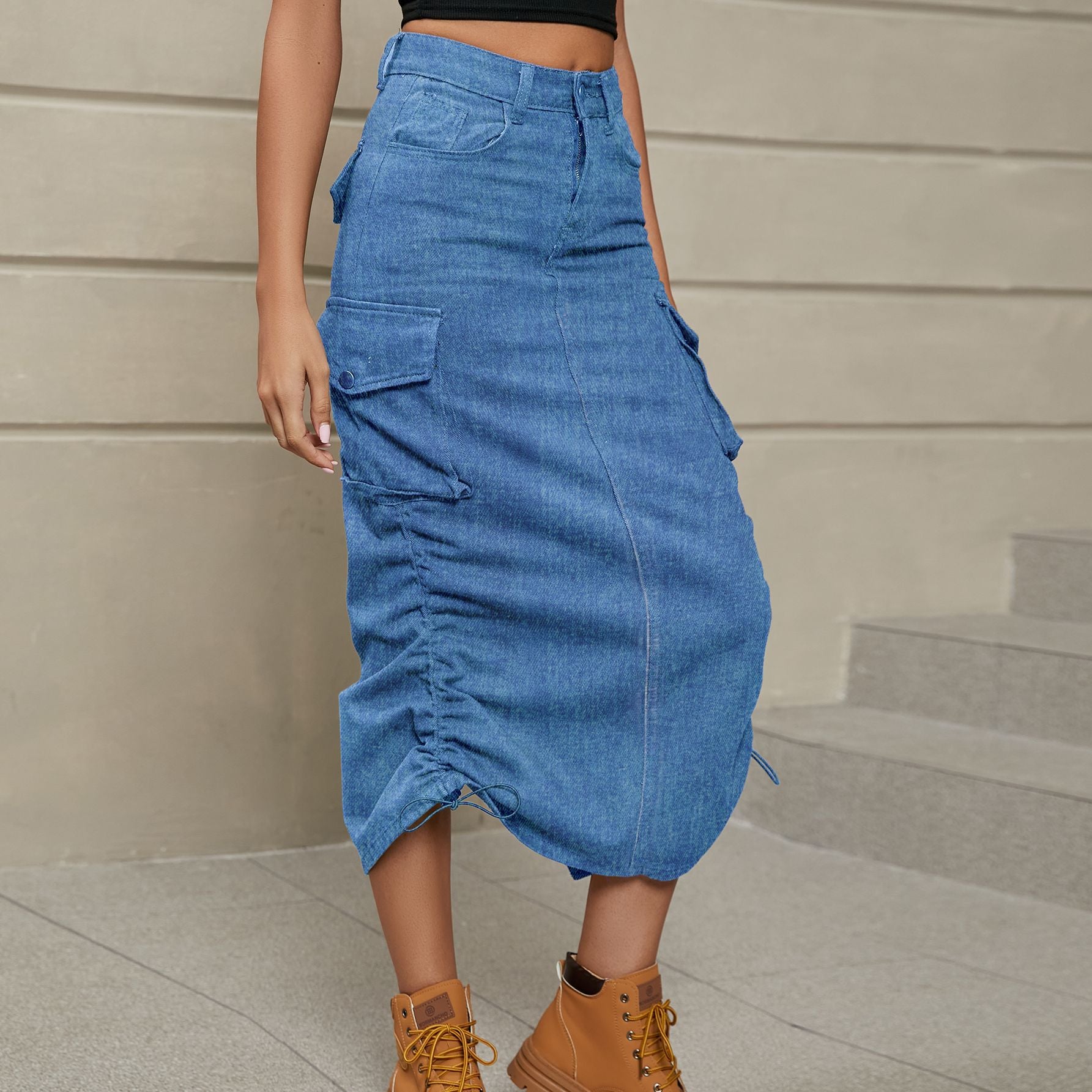 Front left facing view of model wearing drawstring ruched skirt in the color denim. Drawstings on both sides of skirt. 