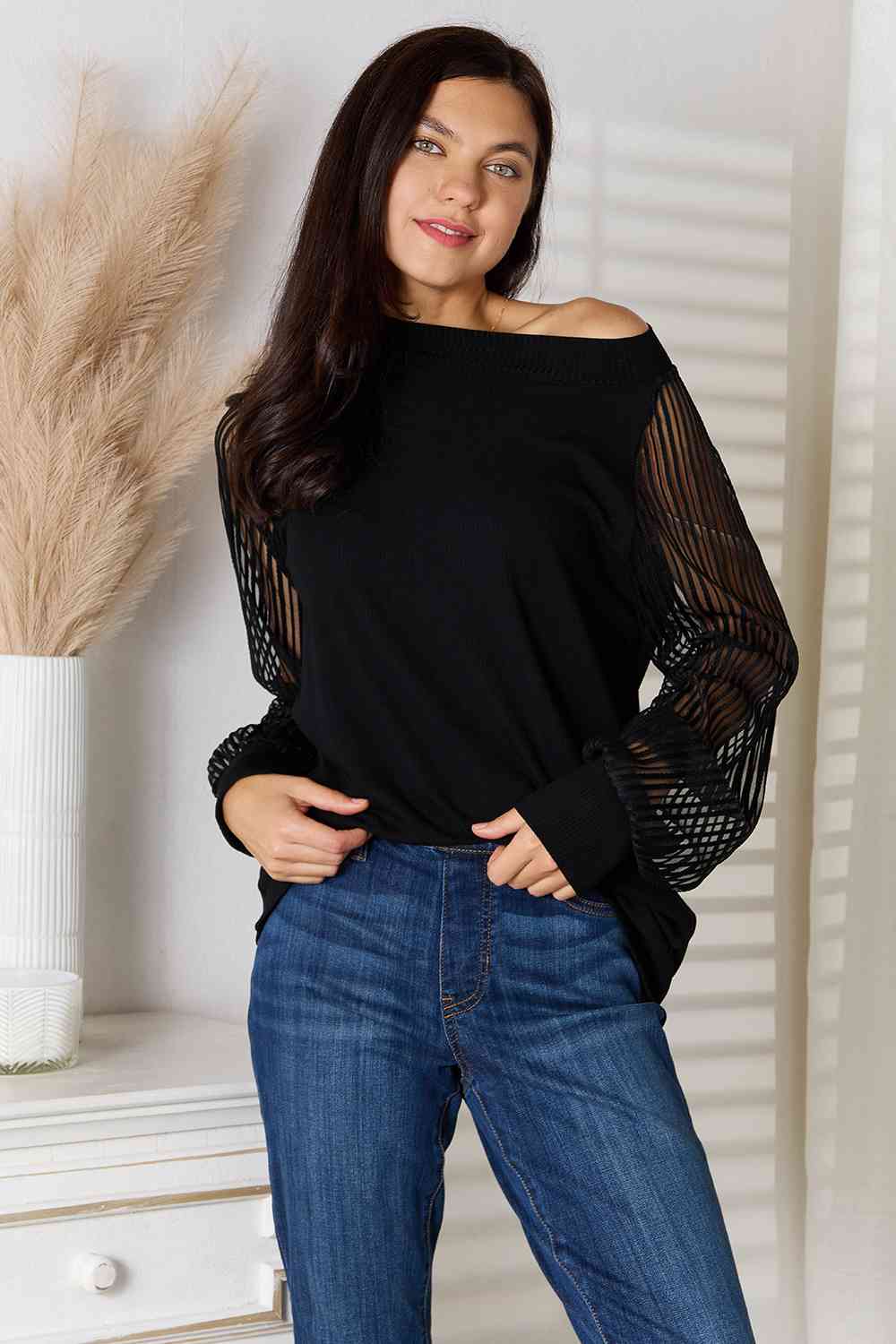 Front view of model wearing black sheer long sleeve blouse 