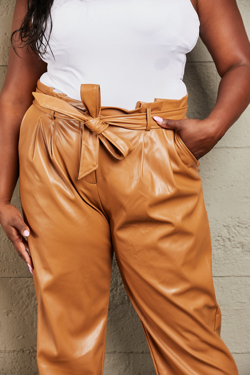 Front view of model wearing Heyson Faux Leather Paperbag Pants in plus size
