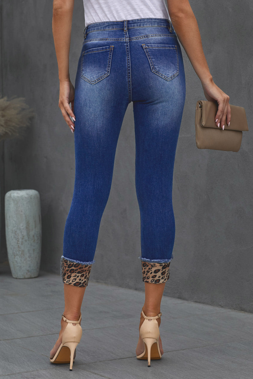 Model back facing view of  Leopard Printd Denim Cropped Jeans.