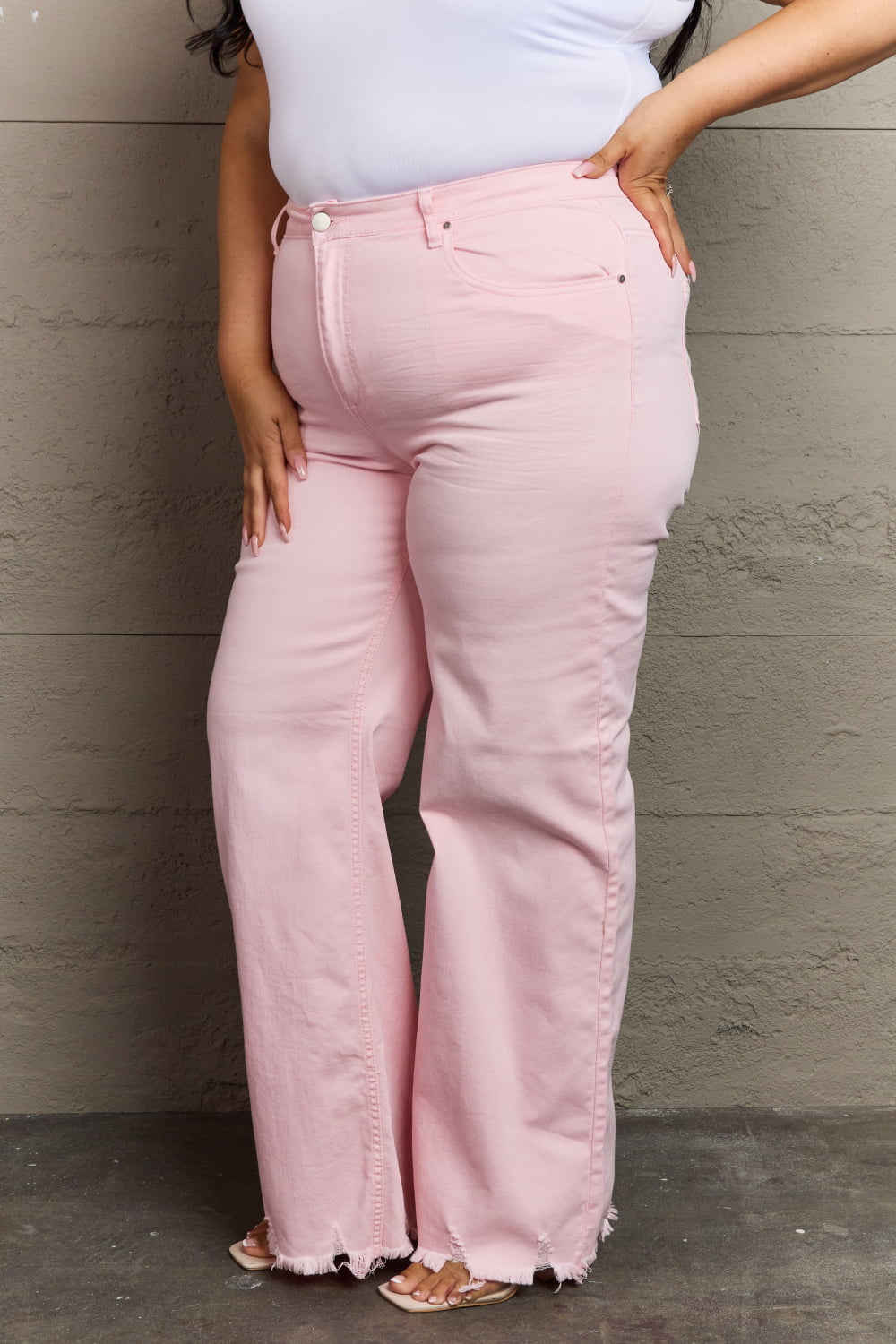 Front view of Plus Size model wearing RISEN Raelene Full Size High Waist Wide Leg Jeans in Light Pink 