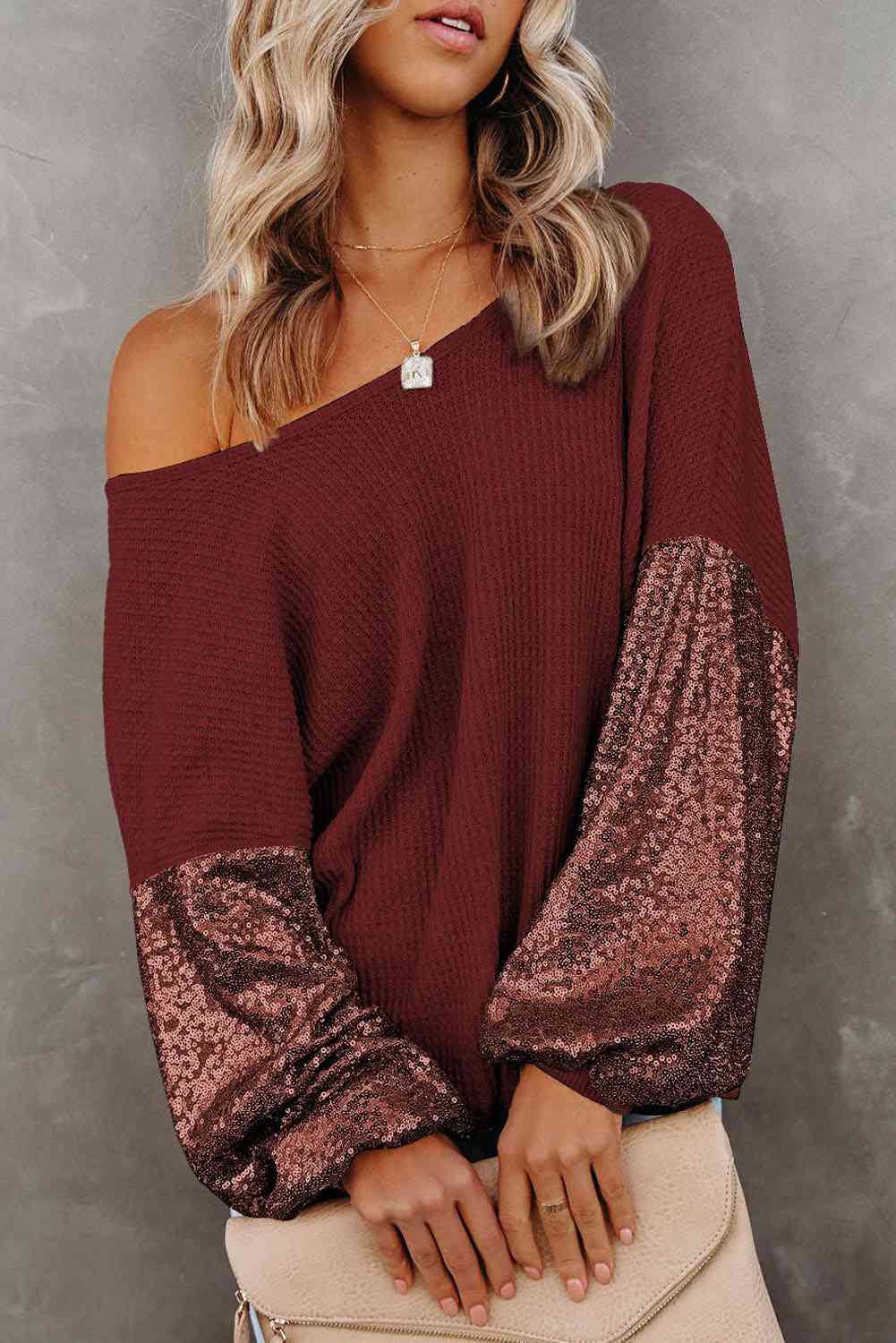 Front view of model wearing sequin sleeve waffle knit blouse in the color wine