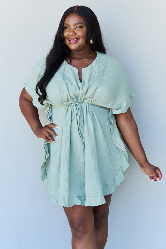 Front view of model wearing plus size ruffle hem dress with drawstring waistband 