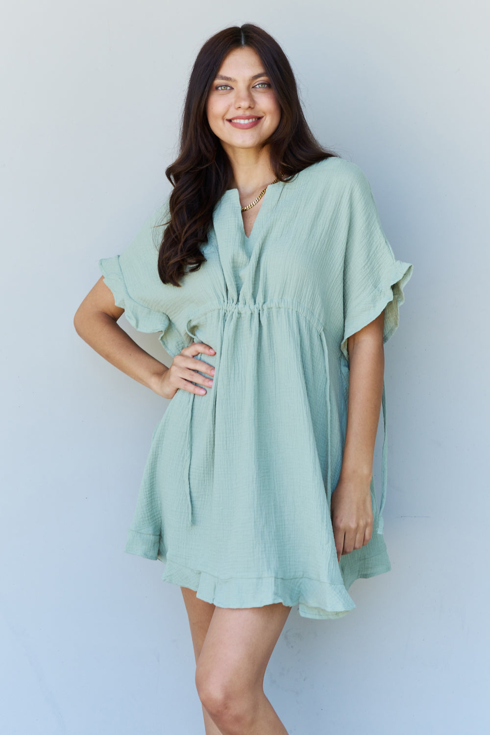 Front view of model wearing ruffle hem dress with drawstring waistband